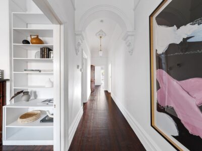 a hallway with a shelf and a bookcase